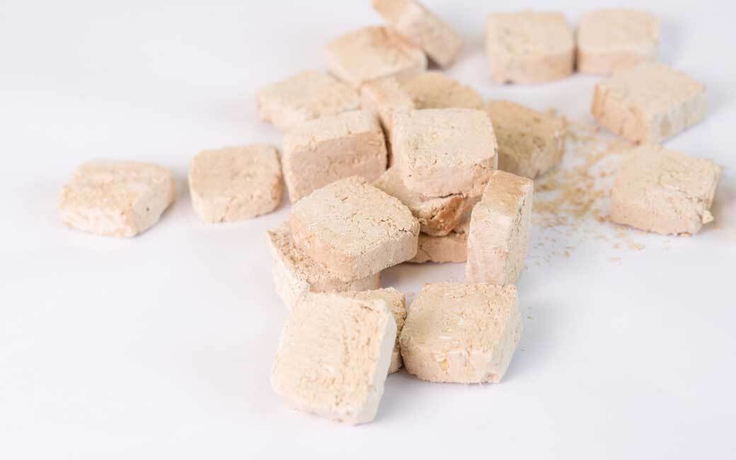 Freeze Dried Chicken Meat Cookie pieces served out of the pouch, can be crushed into a meal topper. A natural chicken dog treats for dogs and cats from Michinoku Farm Singapore