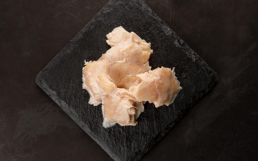 Close-up of Retort Young Chicken Fillet showing the natural texture of this chicken tender dog treats. Soft, mashable texture for seniors, puppies, a healthy retort treat from Michinoku Farm Japan